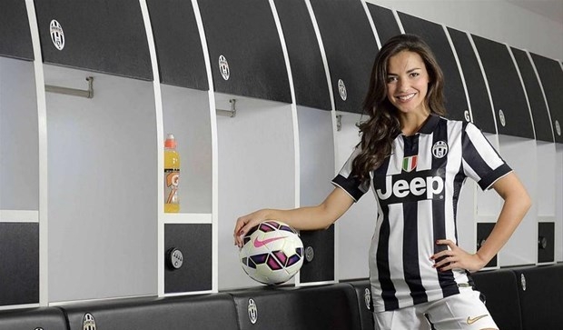 Красотка с форме футбольного клуба Ювентус стоит в раздевалке для спортсменов