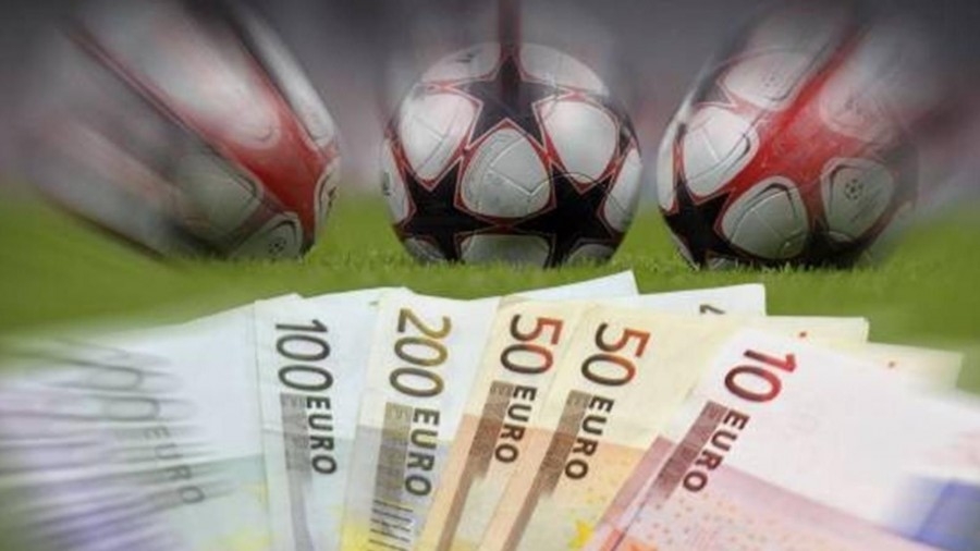 Веер из купюр евро на фоне трех футбольных мячей