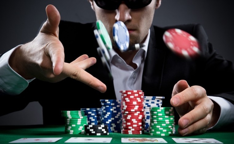 Игрок в покер, скрывающий лицо за темными очками, швыряет фишки в своего оппонента