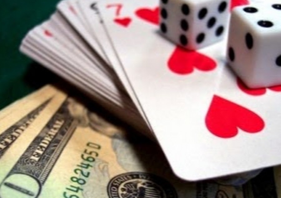 Доллары, игральные карты и кости для крэпса на игровом столе