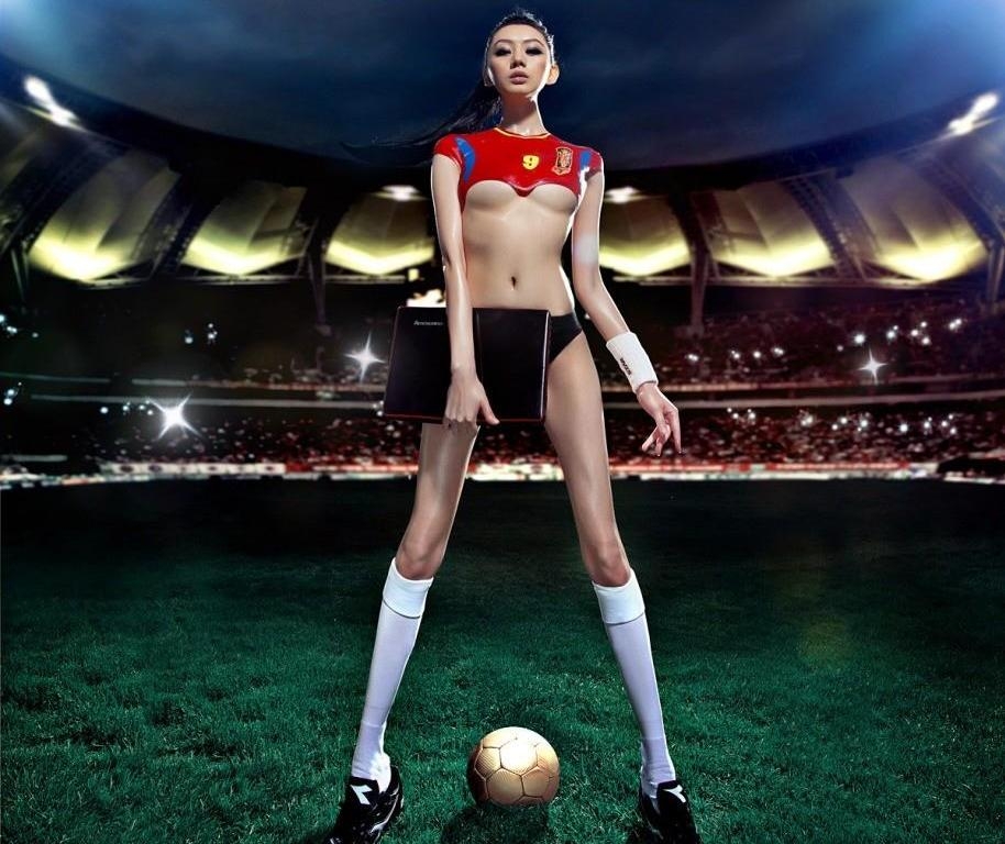 Длинноногая азиатка с выпадающей грудью стоит на футбольном поле