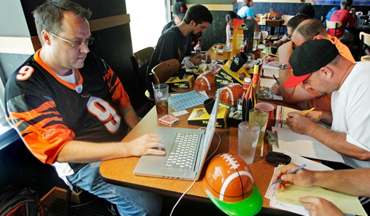 Мужчины играют в фэнтези спорт за компьютерами