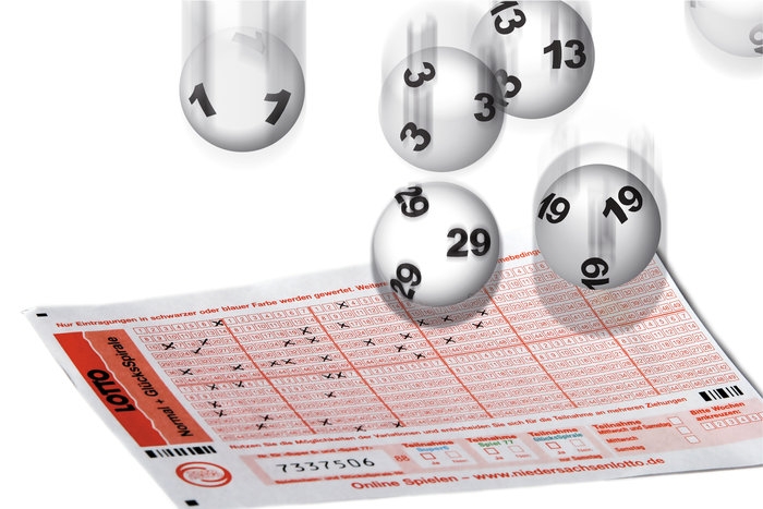 Шары из лототрона с выигрышными номерами летят на лотерейный билет