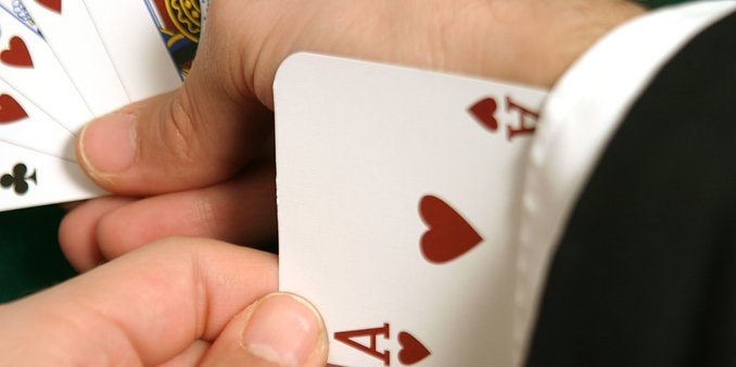 Мужская рука достает червовый туз из рукава