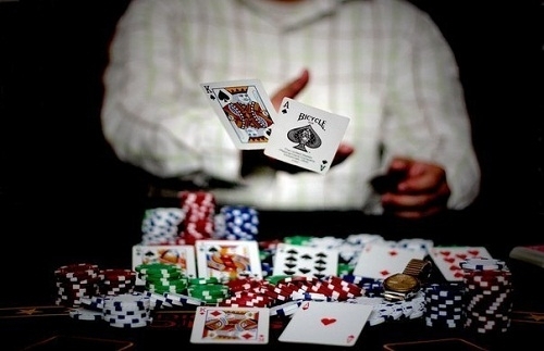 Игрок в покер бросает две карты - король пик и туз пик