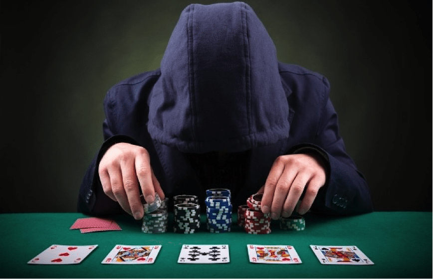 Игрок скрывается за капюшоном, сидя за покерным столом