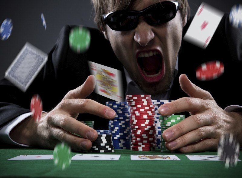 Разяренный игрок в покер разбрасывает карты и фишки