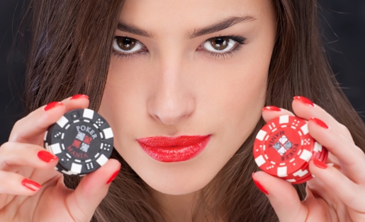 Загадочная шатенка с пронзительным взглядом демонстрирует черные и красные фишки для покера