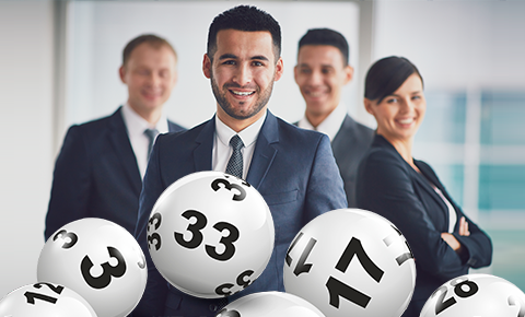 Компания молодых людей в строгих костюмах и лотереынйе шары крупным планом