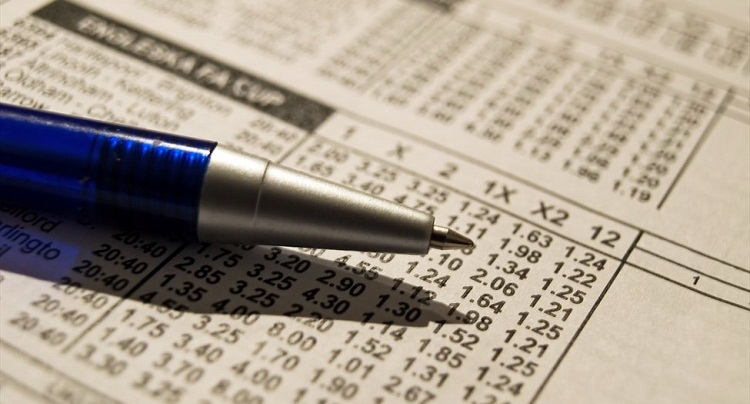 Ручка лежит на билете для совершения ставок