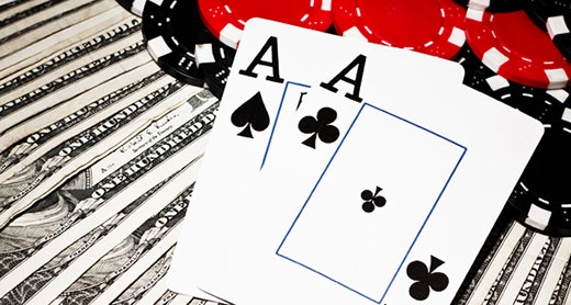 Два туза лежат на долларовых купюрах и фишках казино