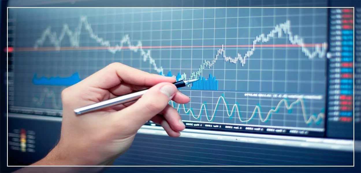 Чеовек указывает ручкой на точку в электронном графике