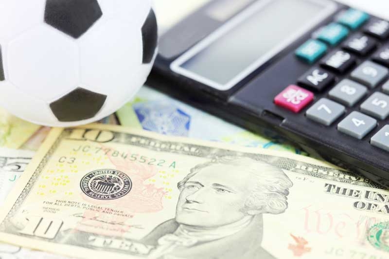 Футбольный мяч, доллары и калькулятор