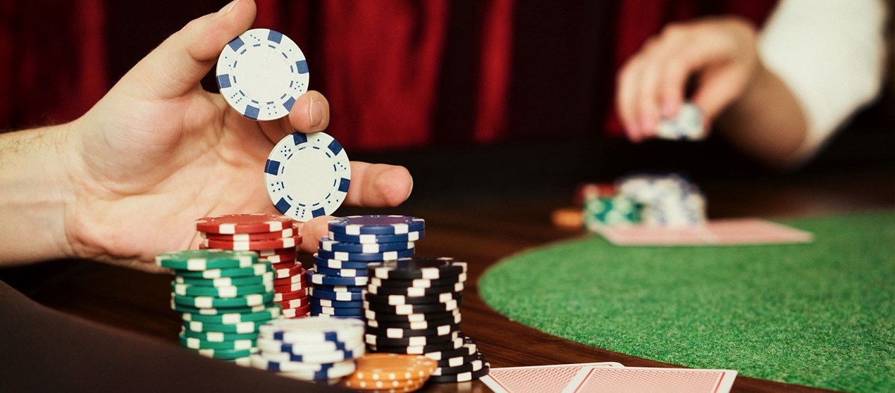 Мужская рука держит фишки для покера