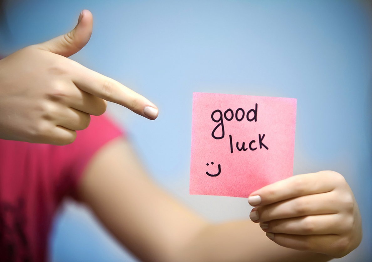 Надпись "Good Luck" на листике в руках девушки