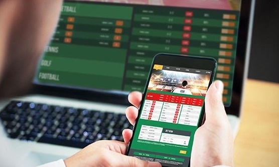 Беттер смотрит на страницу БК в ноутбуке и смартфоне