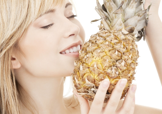 Привлекательная блондинка крупными планом с ананасом в руках