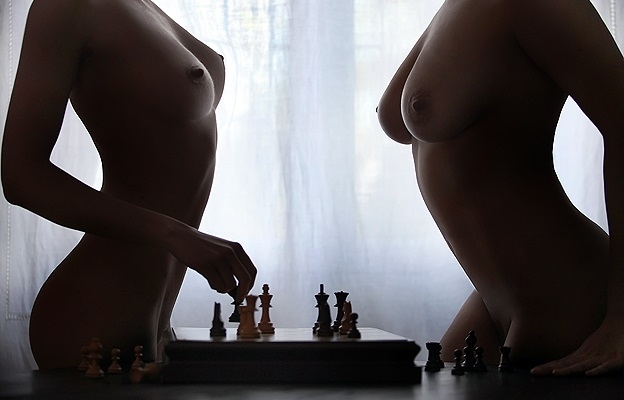 Обнаженные тела двух красоток по разные стороны шахматной доски