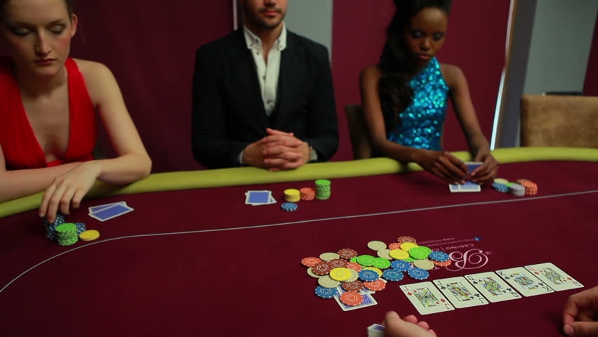 Безэмоциональные игроки за столом для покера в ожидании раздачи