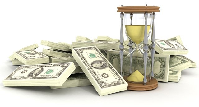 Песочные часы и пачки долларовых купюр