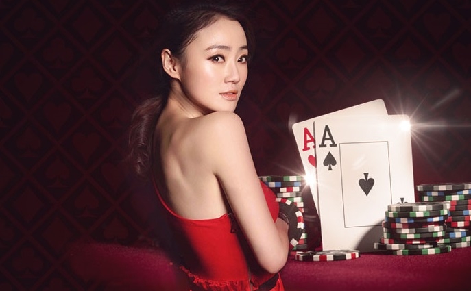 Сексуальная азиатка в красном платье смотрит из-за плеча, а рядом фишки и карты