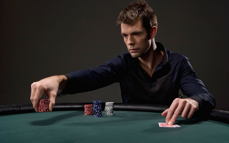 Молодой мужчина решительно совершает ставку в покере