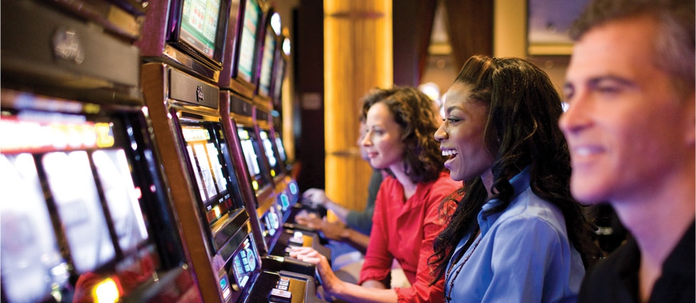 Игроки сидят в ряд за автоматами