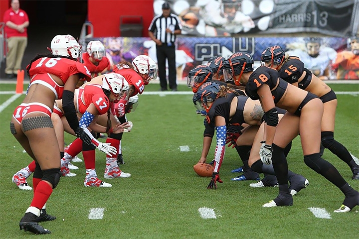 Две команды сексуальных девушек в черной и красной формах приготовились к атаке в американском футболе