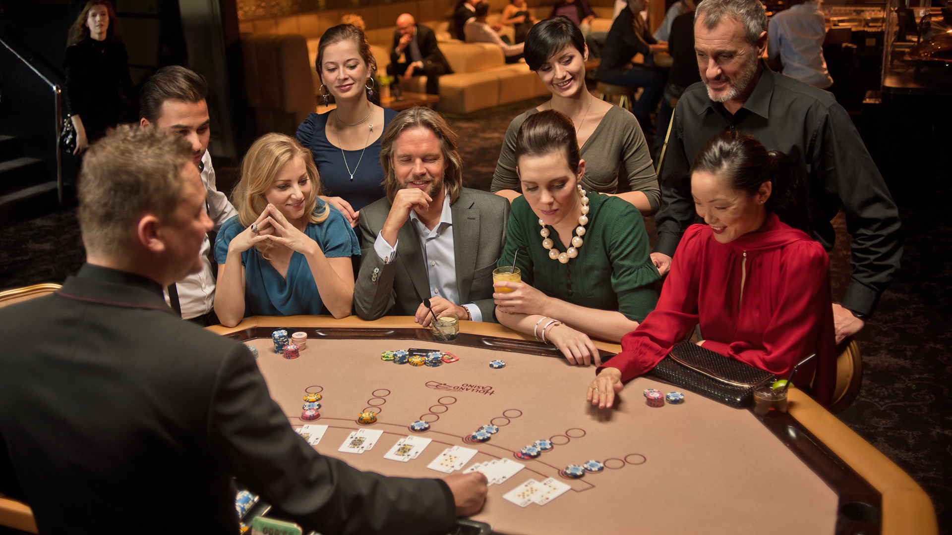 Мужчина крупье ведет игру в блэкджек для богатых клиентов казино