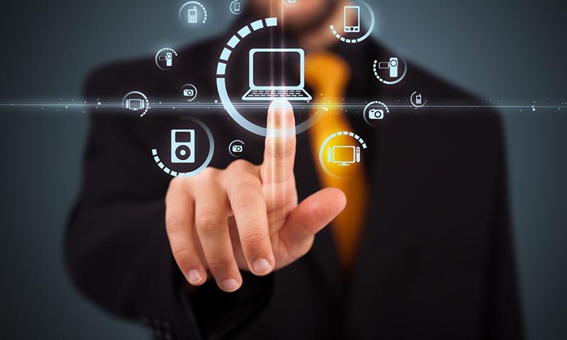 Мужчина в черном костюме с желтым галстуком касается пальцем к прозрачной доске