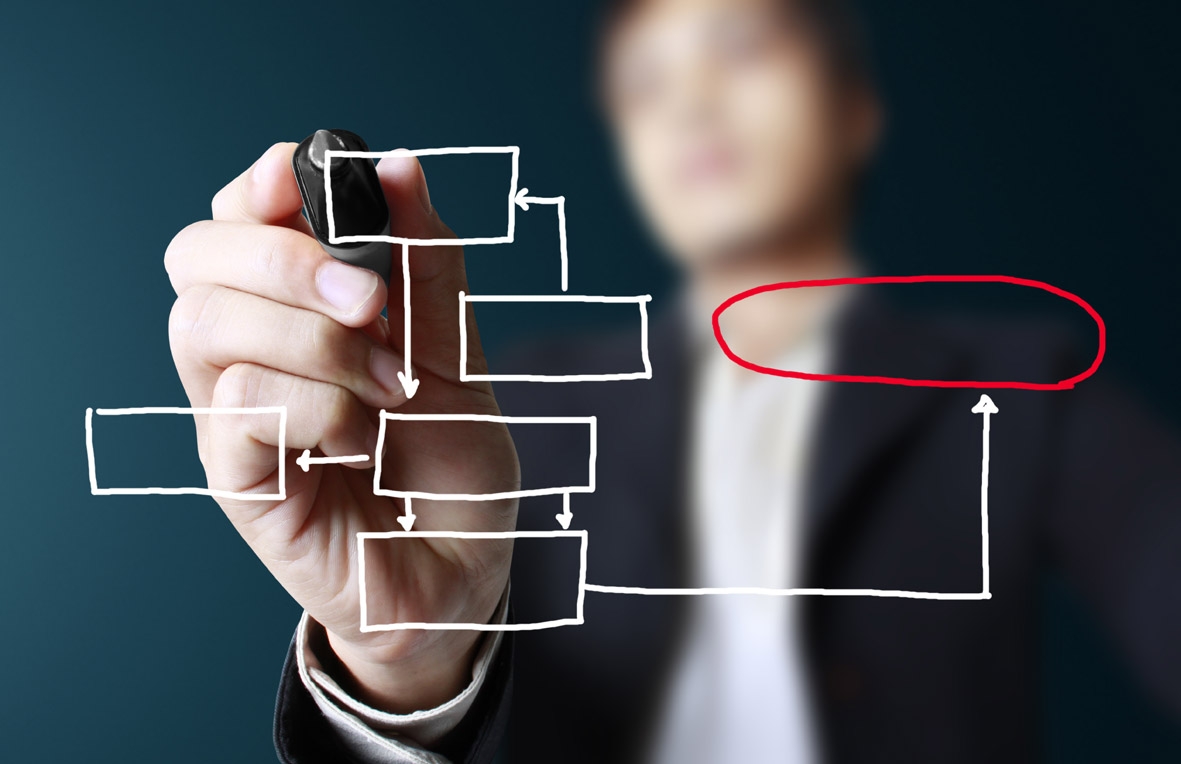 Мужчина рисует схему на прозрачной доске