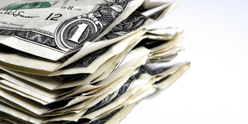 Помятые купюры номиналом в один доллар лежат в стопке