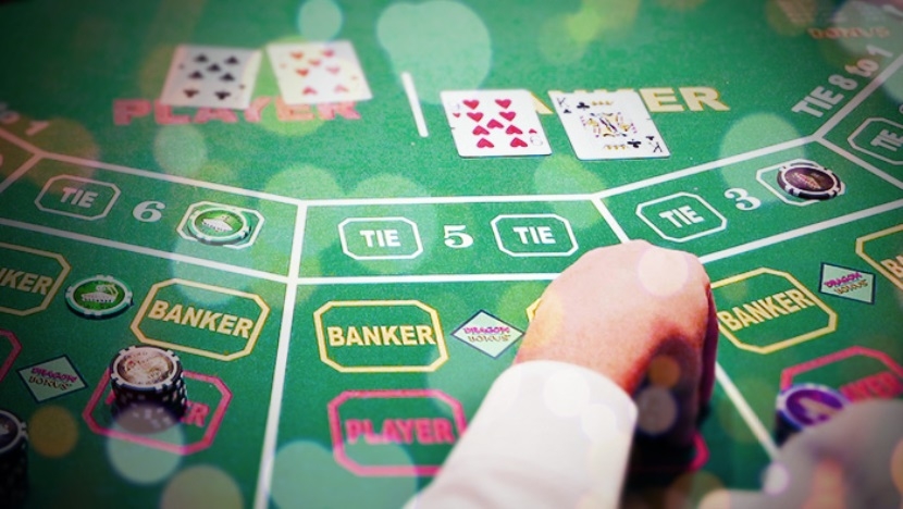 Руки дилера, который раскладывает карты на игорном столе