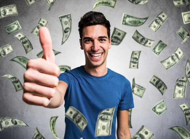 Улыбающийся парень показывает палец вверх, а сверху на него летят доллары