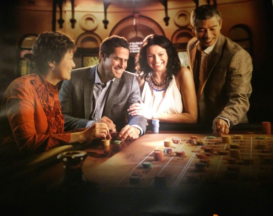 Мужчины и женщины хорошо проводят время за игрой в рулетку в дорогом казино