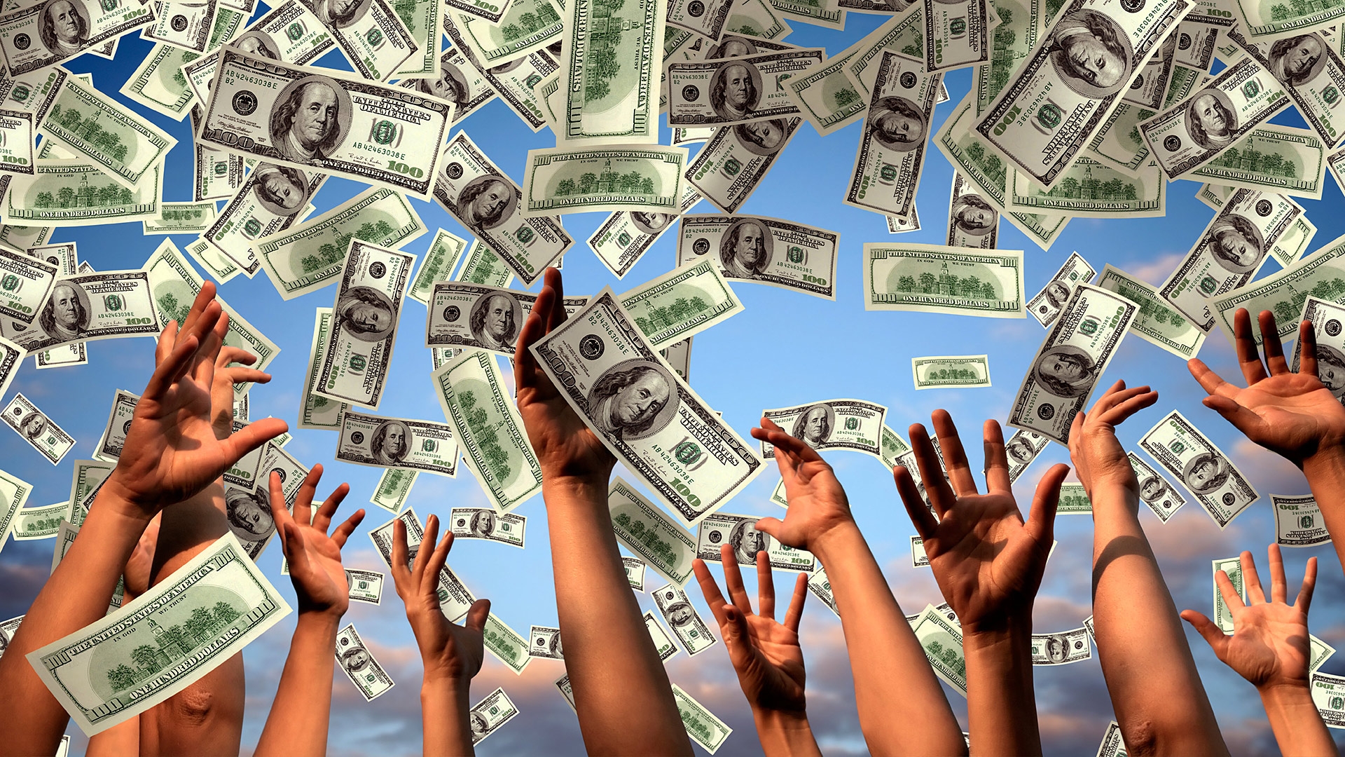 Поднятые вверх руки ловят стодолларовые купюры, которые летят сверху