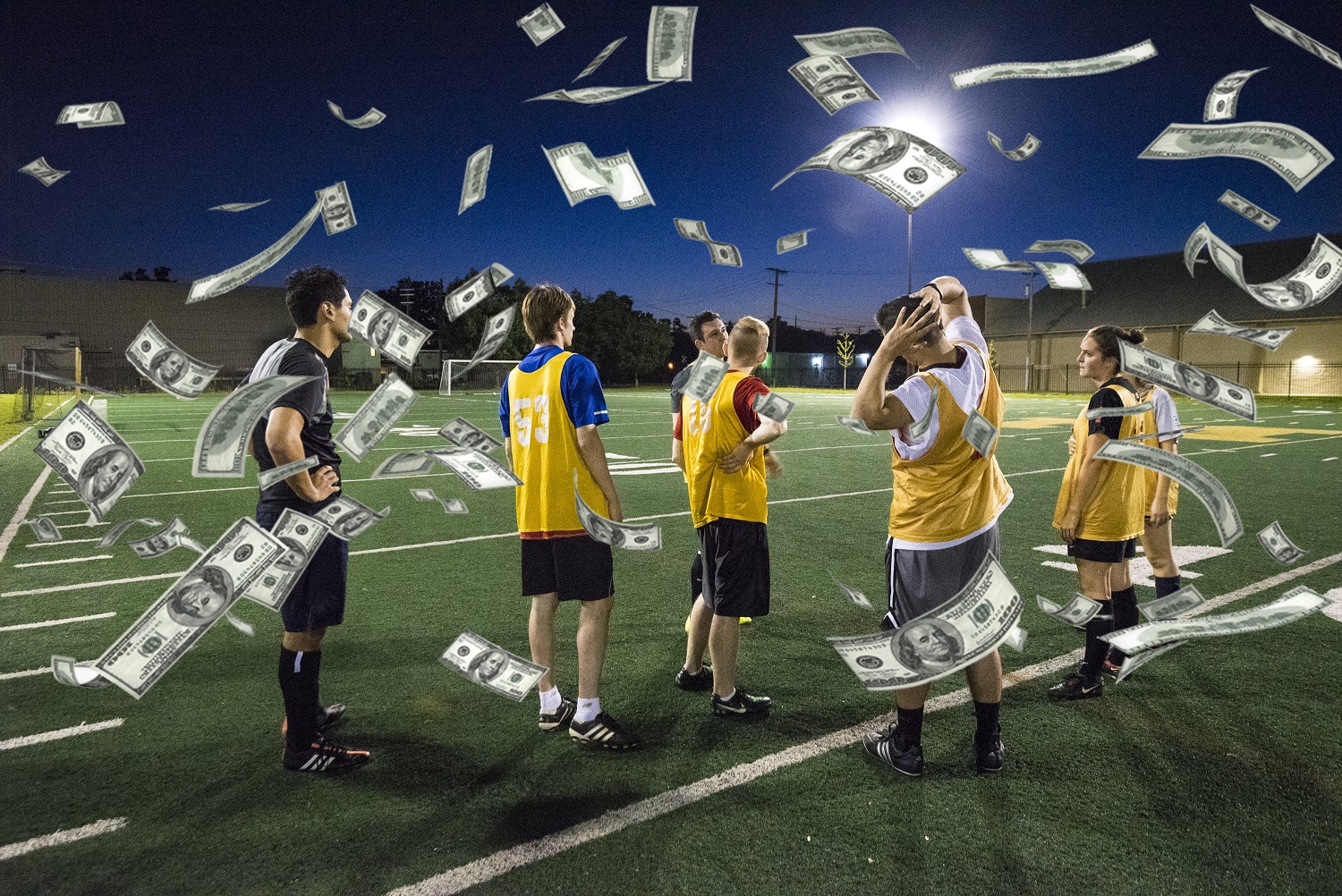 Игроки стоят на футбольном поле, а сверху на них летят доллары