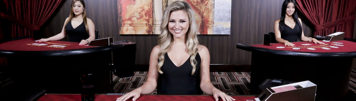 Привлекательные девушки дилеры в черных платьях ждут игроков за столами в виртуальном зале казино