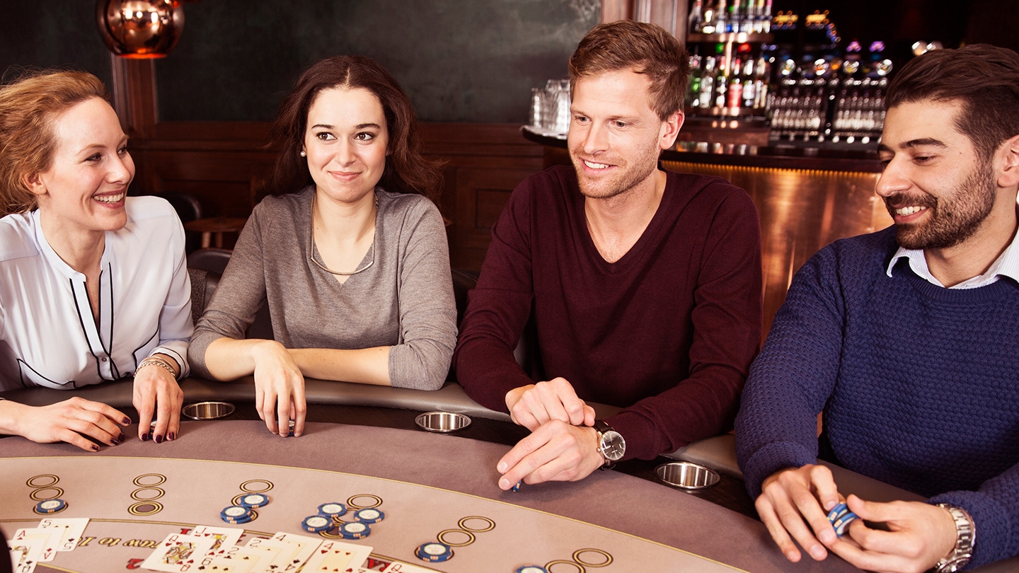 Двое женщин и двое мужчин в ожидании раздачи за столом для блэкджека