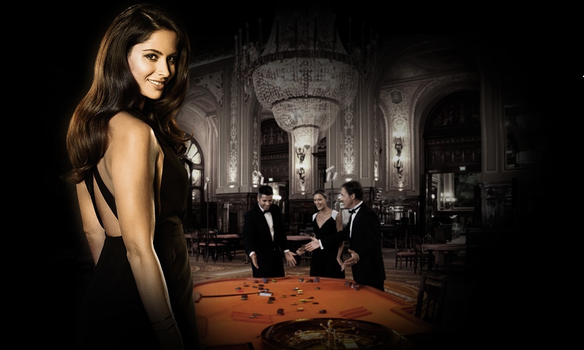 Привлекательная брюнетка в откровенном черном платье стоит в полутьме, а на заднем фоне игроки за столом для рулетки