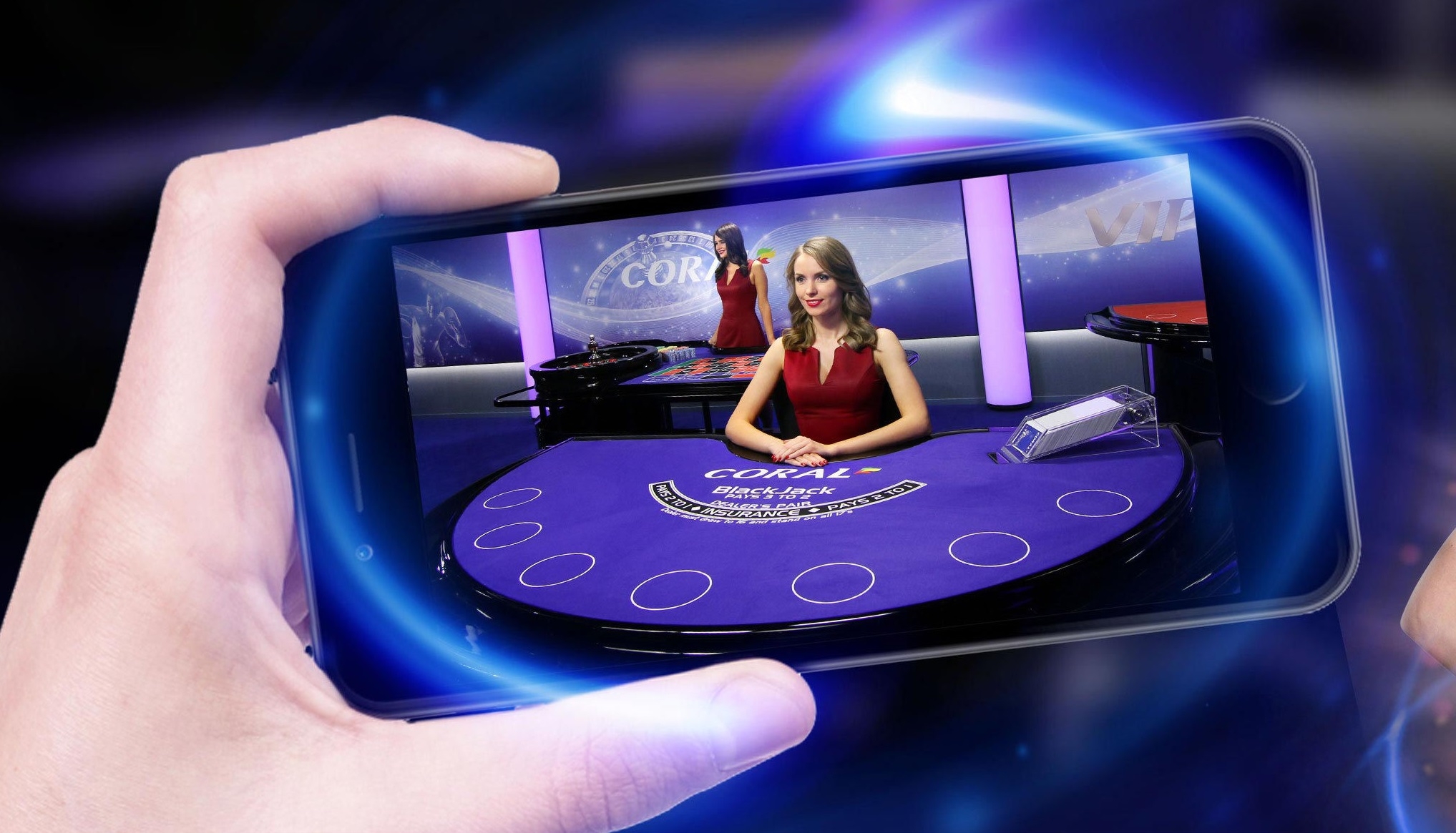 Рука держит смартфон, на котором открыта игра в блэкджек с живым дилером - красивой девушкой в красном платье