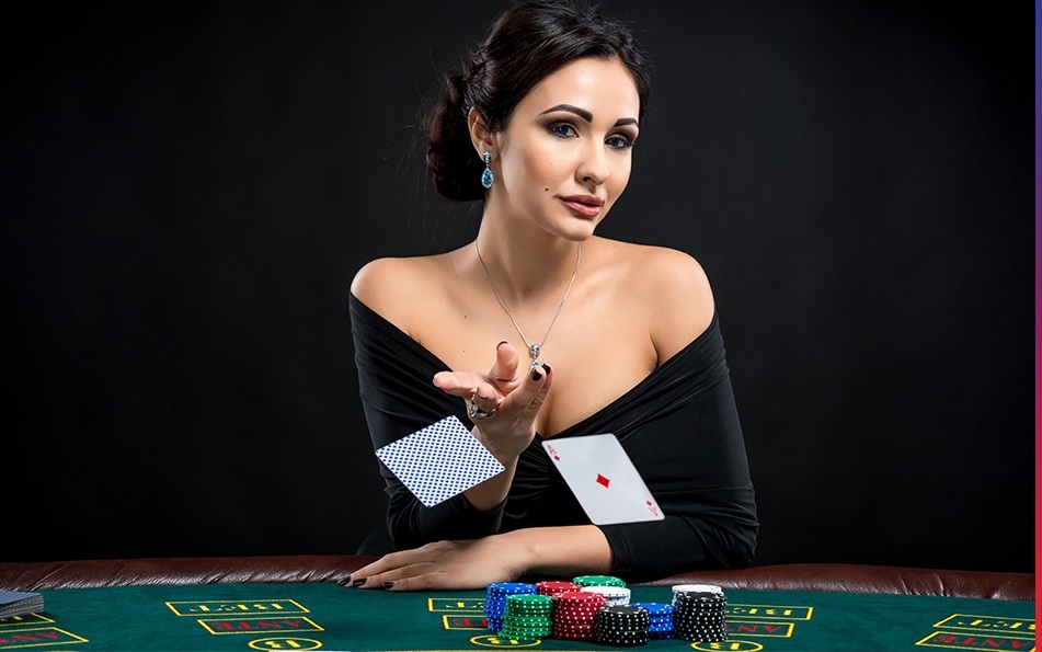 Привлекательная брюнетка в черном платье с откровенным декольте бросает карты на стол для покера