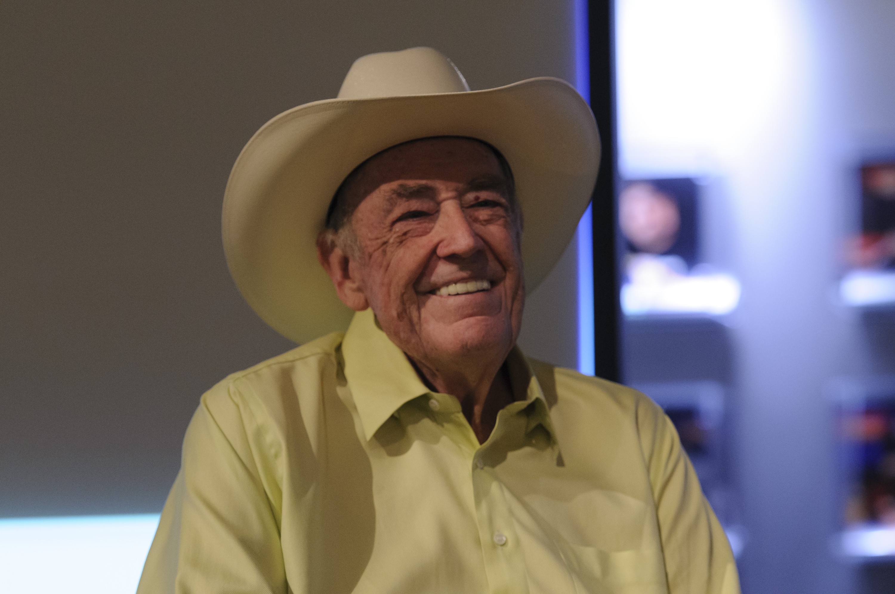 Смеющийся старик Дойл Бранс в своей фирменной шляпе с широкими полями