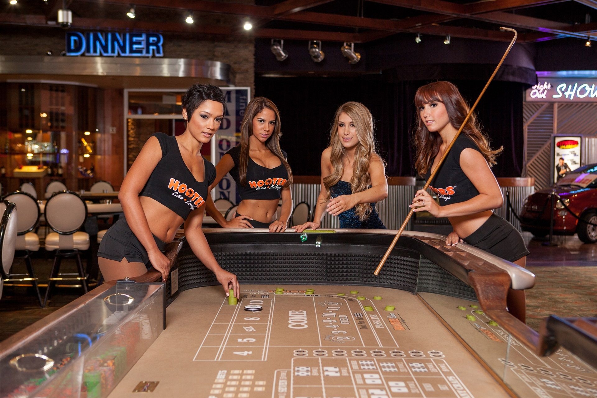 Четверо сексуальных девушек в топах и коротких обтягивающих шортах играют в крэпс в одном из казино Лас-Вегаса