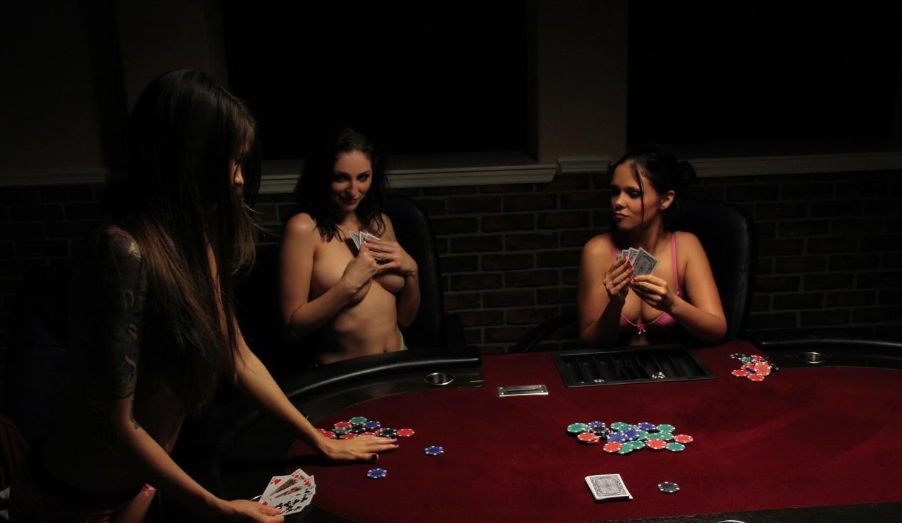 Три полуобнаженных девушки в процессе игры в покер на раздевание