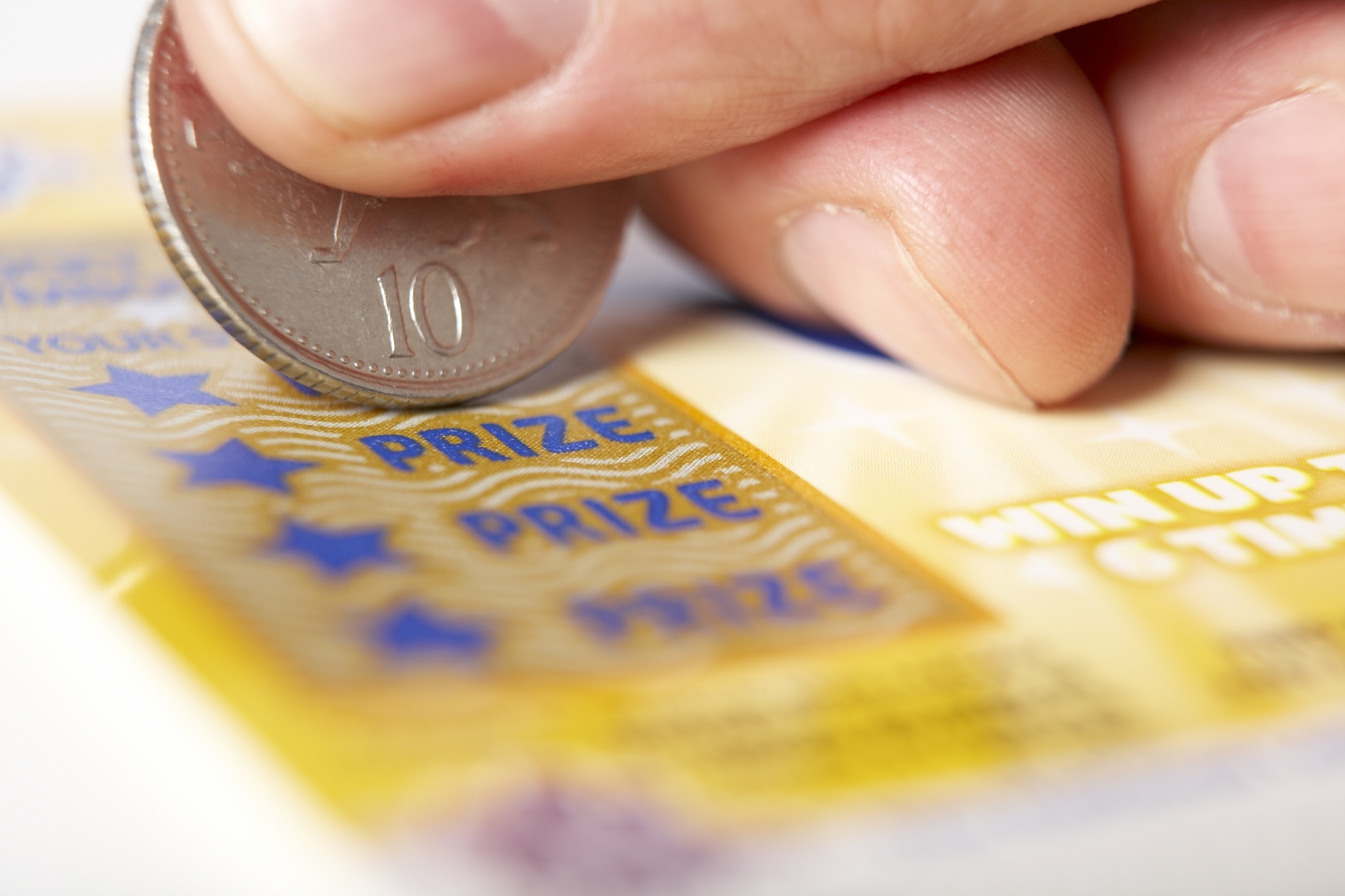 Игрок стирает защитное поле на билете мгновенное лотереи