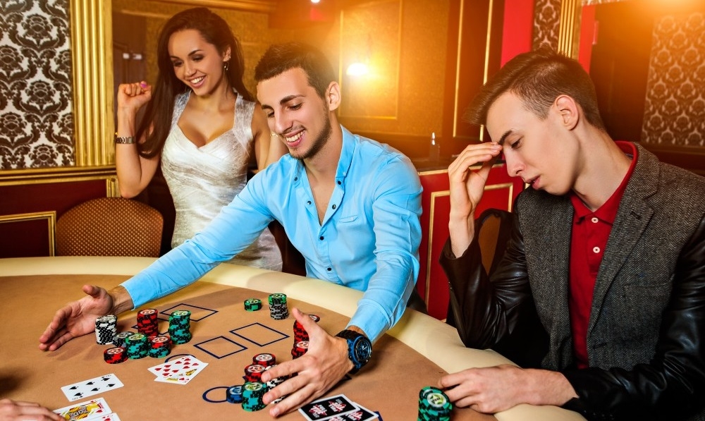 Двое парней играют в покер. Один проиграл, другой сорвал куш, и его девушка, сексуальная брюнетка в мини-платье, радуется победе