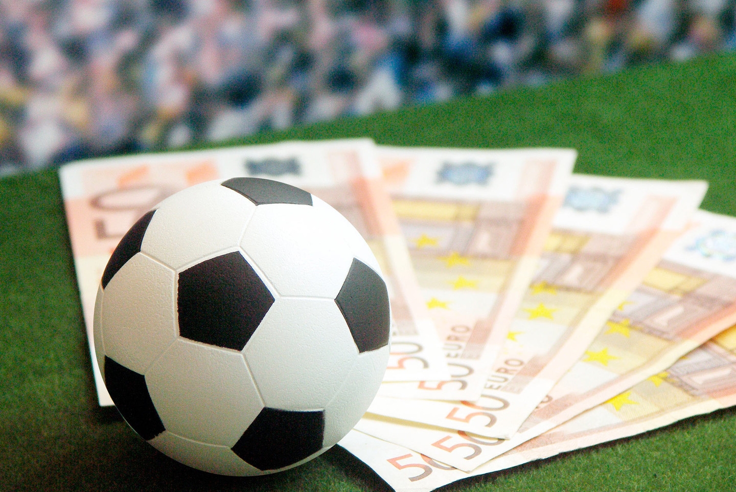 Футбольный мяч лежит рядом с денежными купюрами