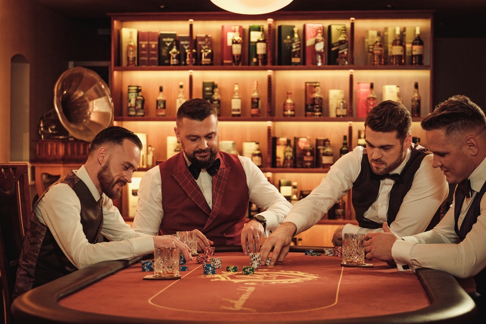 Четверо элегантных мужчин играют в покер, распивая виски