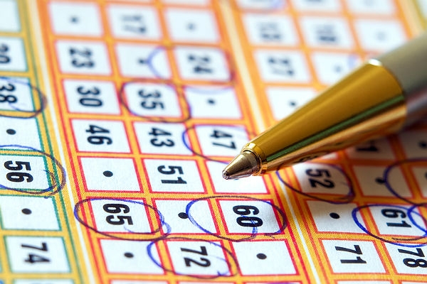 Лотерейный билет, на котором ручкой обведены выигрышные номера